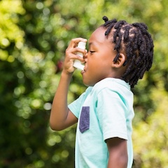 Boy using an asthma inhaler 